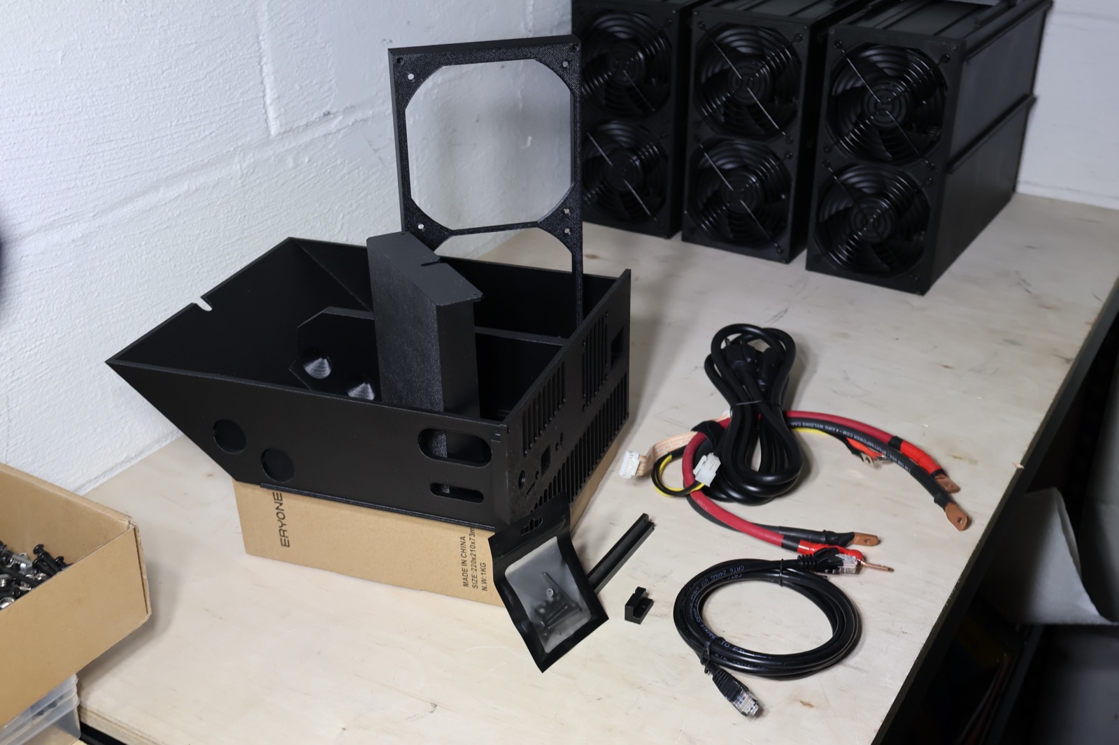 Kit parts laid out on the bench with finished rigs behind